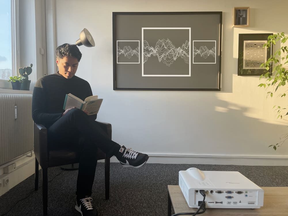 man reading while digital art frame
